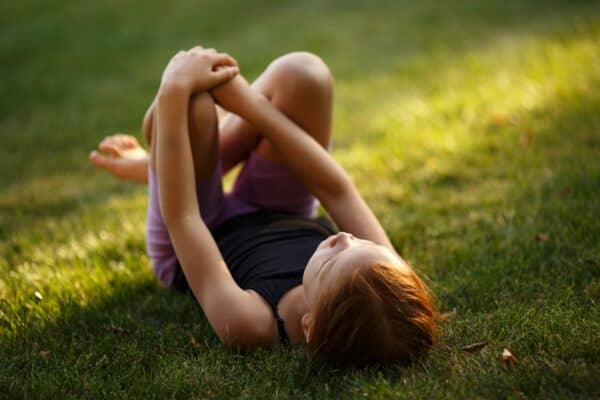 calm child lying on green grass