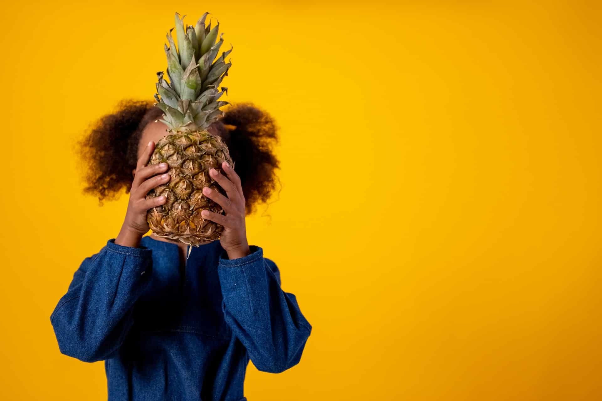 pexels-cottonbro-4714772 child hiding behind a pineapple